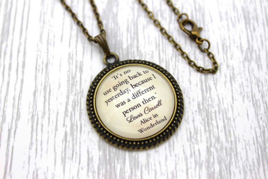 Round necklace with the quote "It's no use going back to yesterday, because I was a different person then" printed on it
