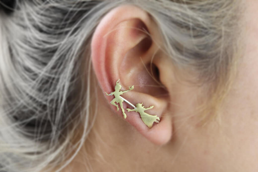 Ear climber with two figures flying. One is Peter Pan and the other is Wendy.
