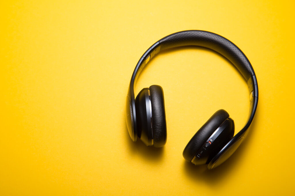 Black headphones sitting on a bright yellow background