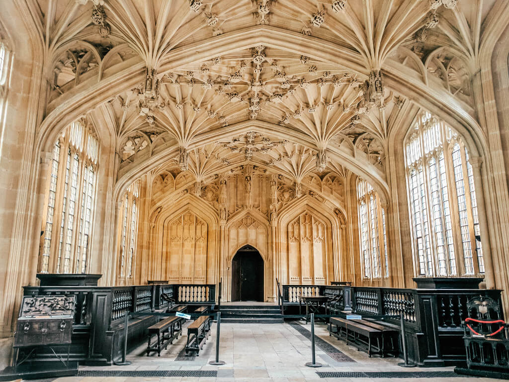 Stone interior of the Divinity School at Oxford, with tall windows