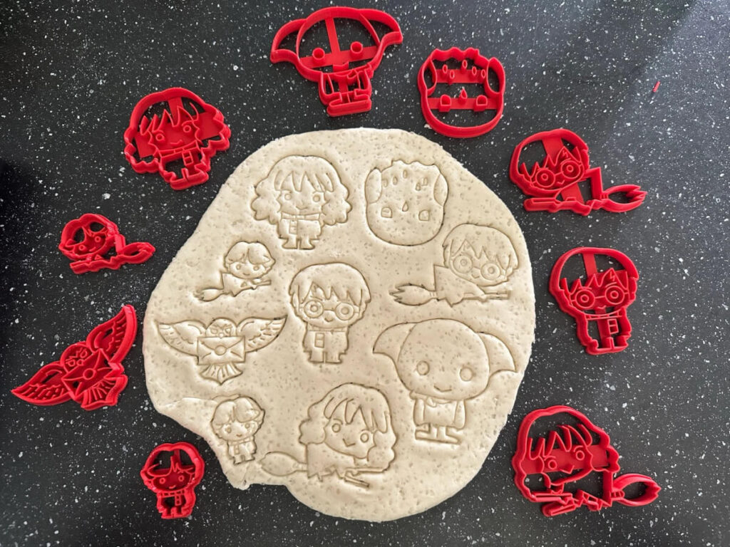 9 different Harry Potter character cookie cutters surrounding cookie dough with the imprints on it by Kdo3DCreations
