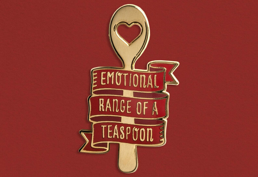 Enamel Pin shaped like a spoon that reads "emotional range of a teaspoon" by MacGuffinGoods