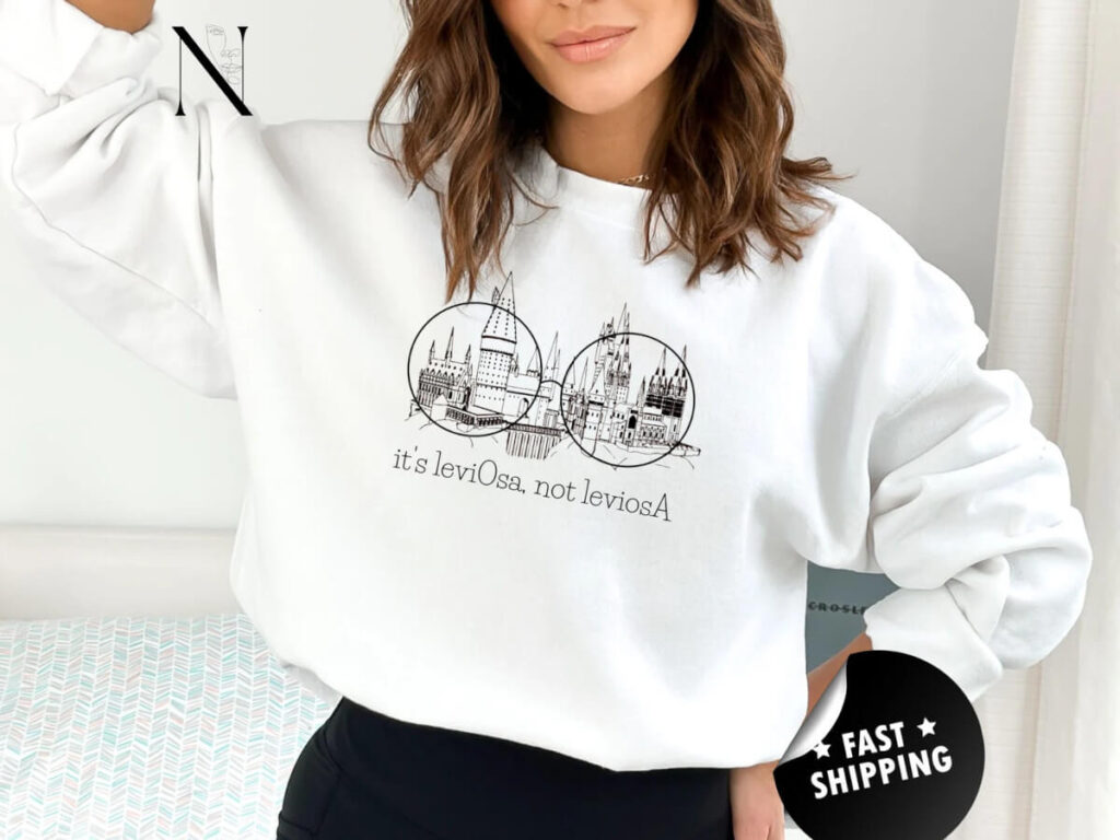 White sweatshirt with a picture of Hogwarts Castle and the words "it's leviOsa, not leviosA" by Noir0711