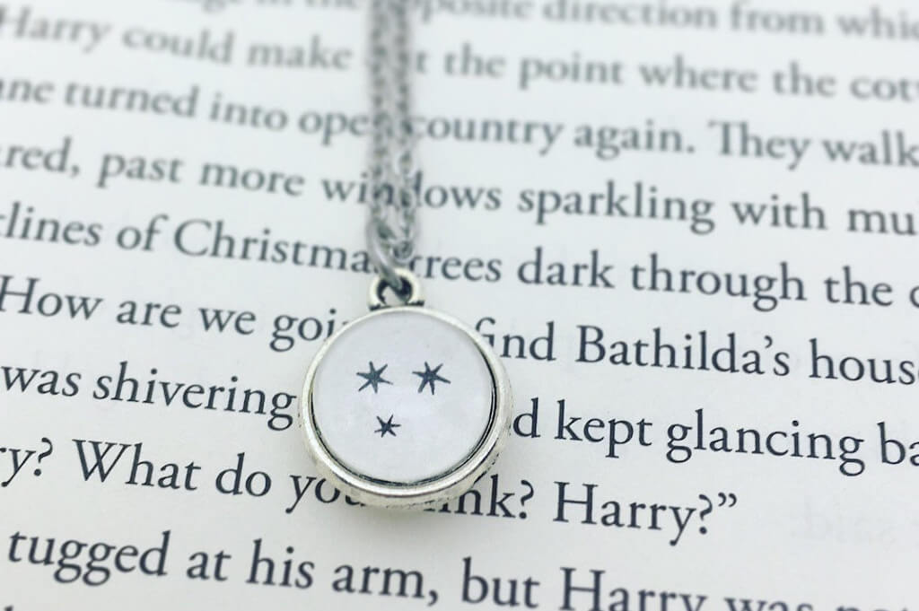 Silver necklace with paper Harry Potter chapter stars under a clear dome by Gabigabiheyshop