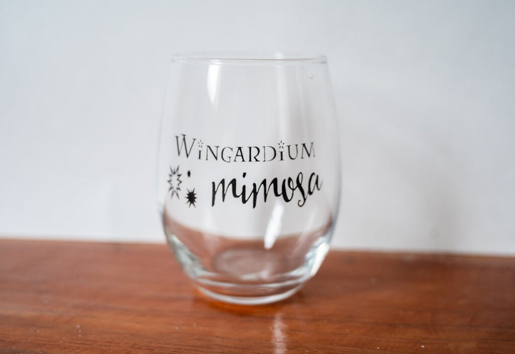 Clear stemless wine glass that says "Wingardium Mimosa" by LoveCityPrintCo