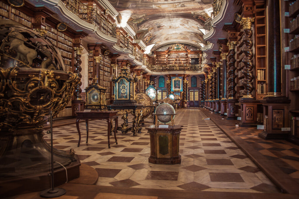 Bookshelf-lined walls of the Klementinum Library in Prague, with square and diamond patterned floors