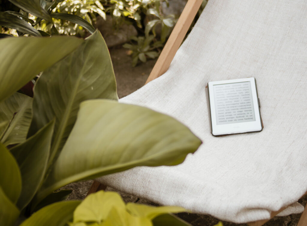 Bianco e-reader seduto su una sedia al di fuori
