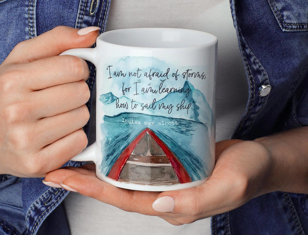 White mug with blue water and red boat illustration, and the text "I am not afraid of storms, for I am learning how to sail my ship." By Please and Thanks Cards