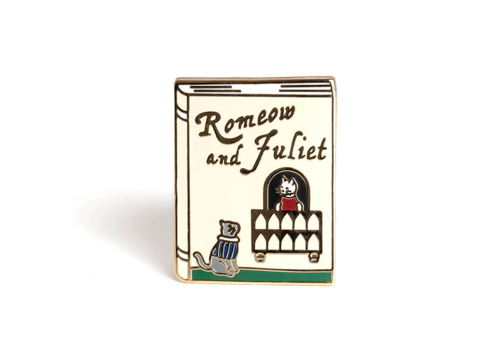 Enamel pin shaped like a book that has cats on it and says "romeow and juliet" by Bona Fide Bookworm