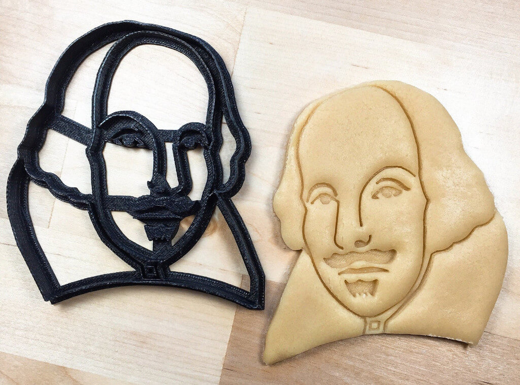 Black cookie cutter next to a cookie in the shape of Shakespeare's face. By Boe Tech LLC