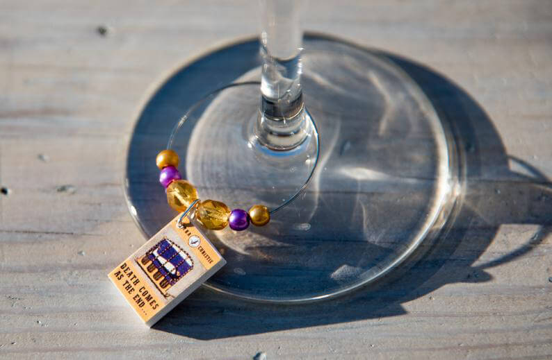 Death Comes as the End wine glass charm on a wine glass. By Marians Garden