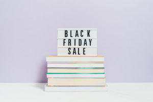 Stack of books with a sign that reads "Black Friday Sale"