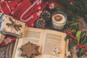 Open book with presents, cookies, and candy canes surrounding it