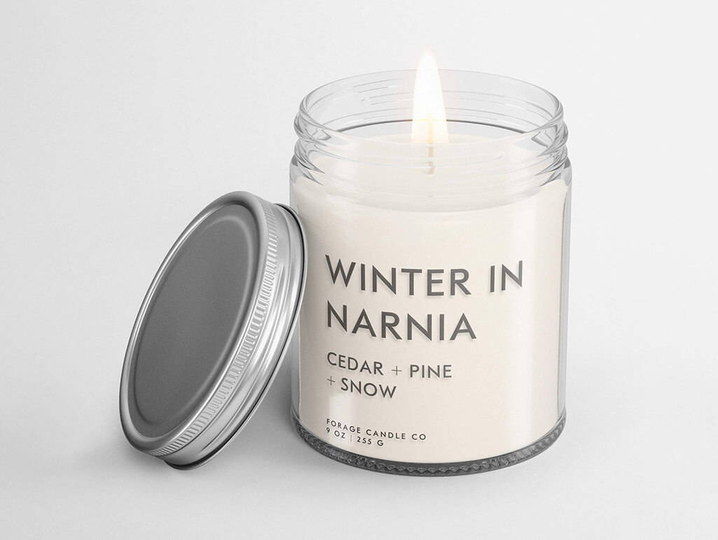 White candle that reads "Winter in Narnia" by Forage Candle