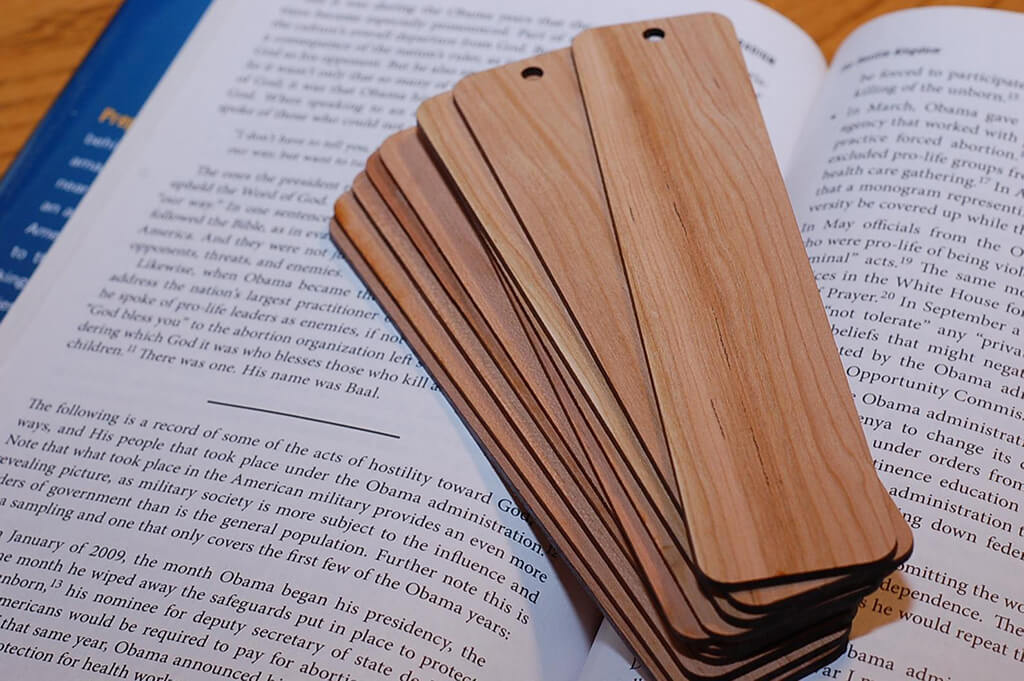 Blank Cherry Wood Bookmarks sitting on top of an open book. By 623 Woodworks