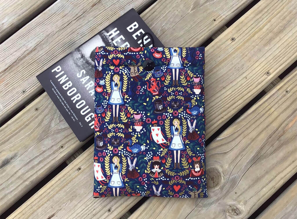 Book sleeve featuring an Alice in Wonderland print by Fabric Bound