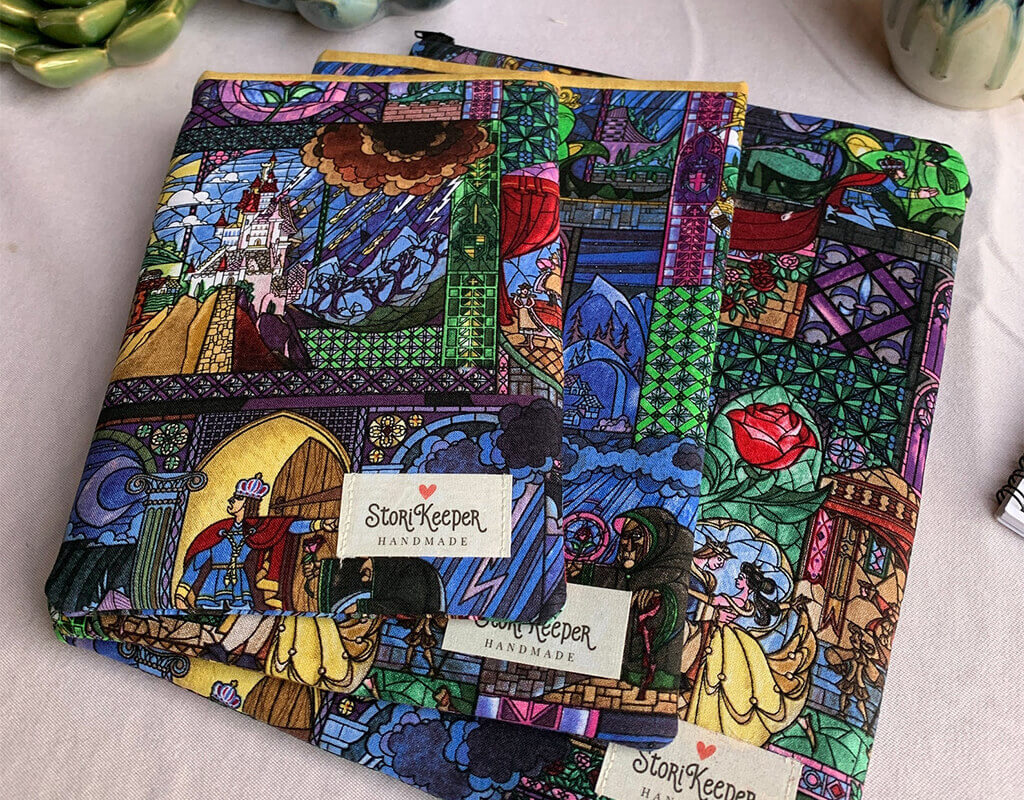 Book sleeve made from stained glass Beauty and the Beast fabric by StoriKeepers