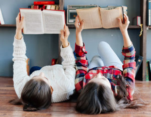 Two girls reading side by side
