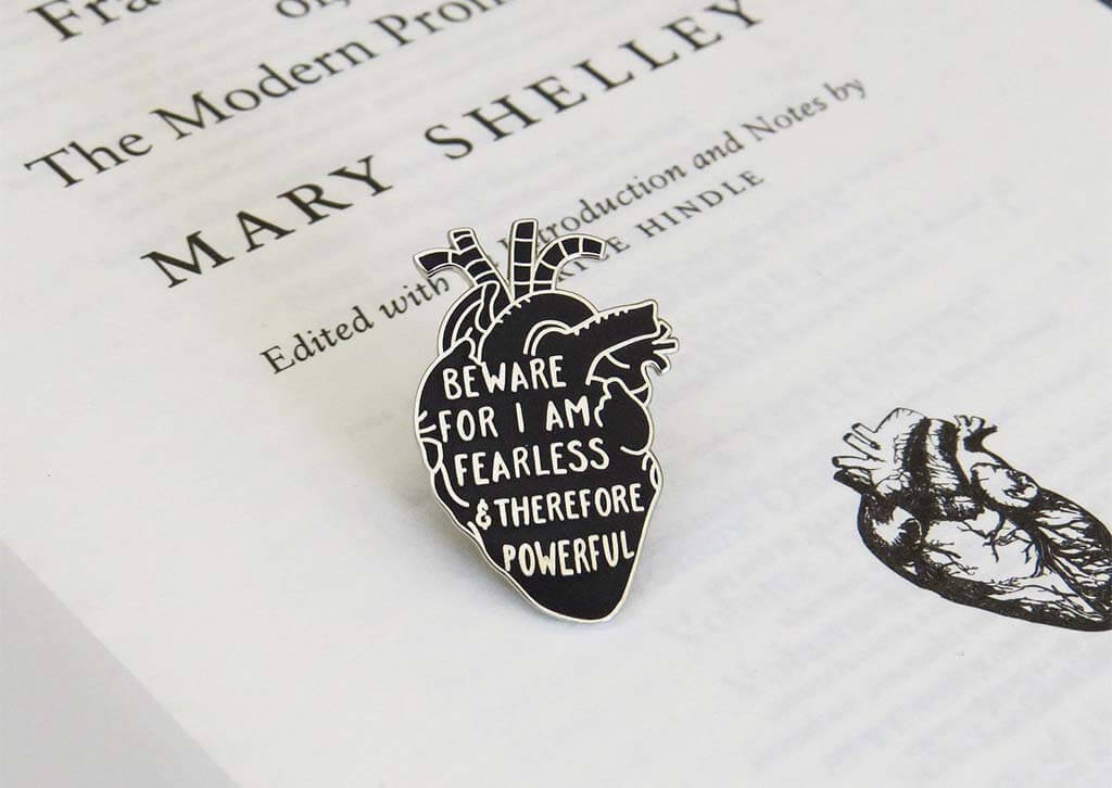 Black anatomical heart-shaped enamel pin with the quote "Beware for I am fearless and therefore powerful" by LiteraryEmporium