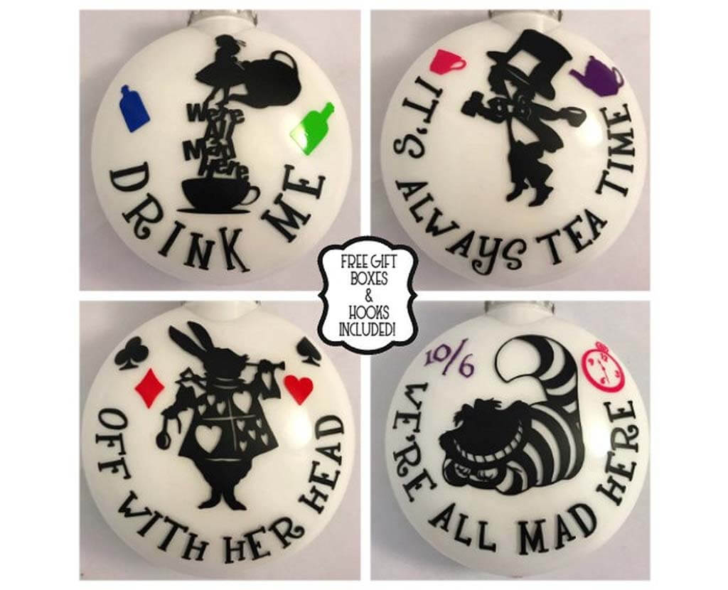 Four different white plastic ornaments with various designs and quotes from Alice in Wonderland by BlastThisDesigns