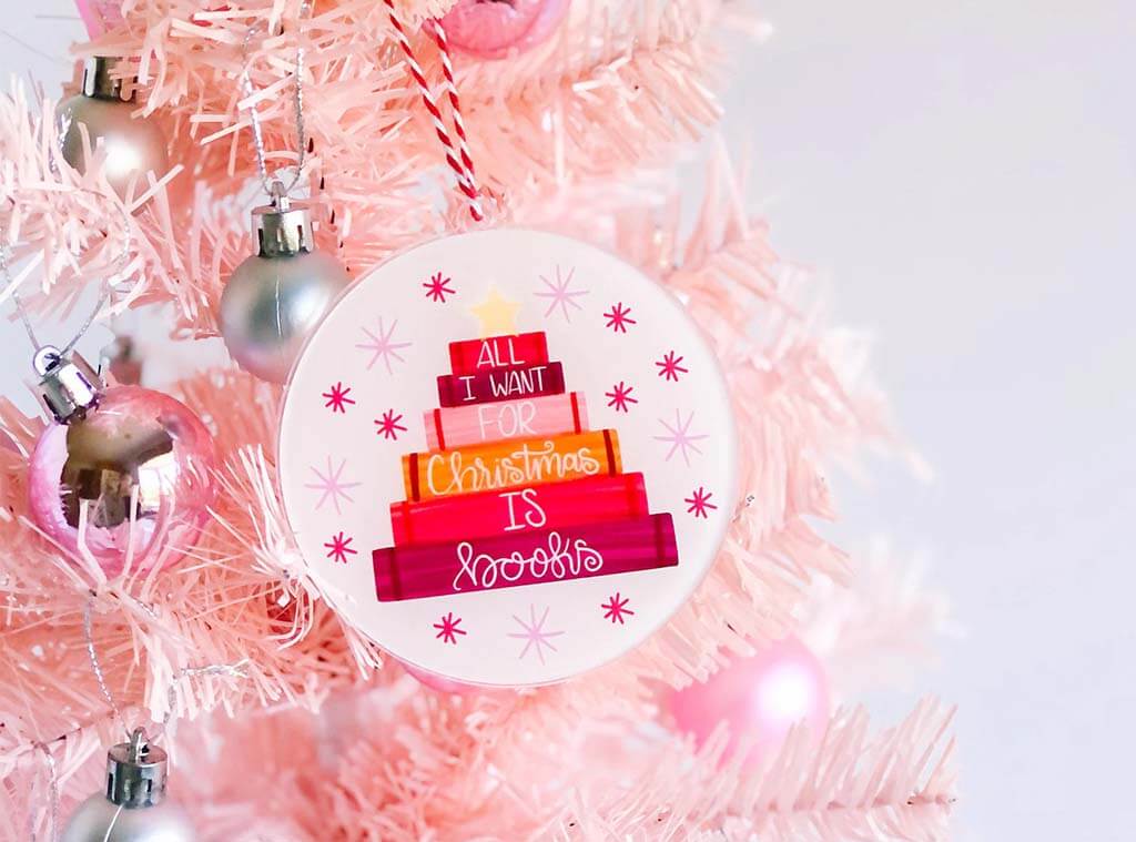 Light pink ornament with a book stack that reads "All I want for Christmas is Books" by EmilyCromwellDesigns