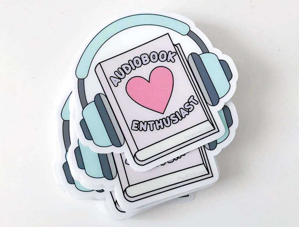 Sticker with headphones on the outside of a book with a heart on it and the words "Audiobook Enthusiast". By MySecretCopy