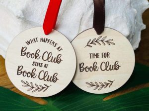 Round wooden ornaments with book club sayings engraved on them by PersonalizedGiftsND