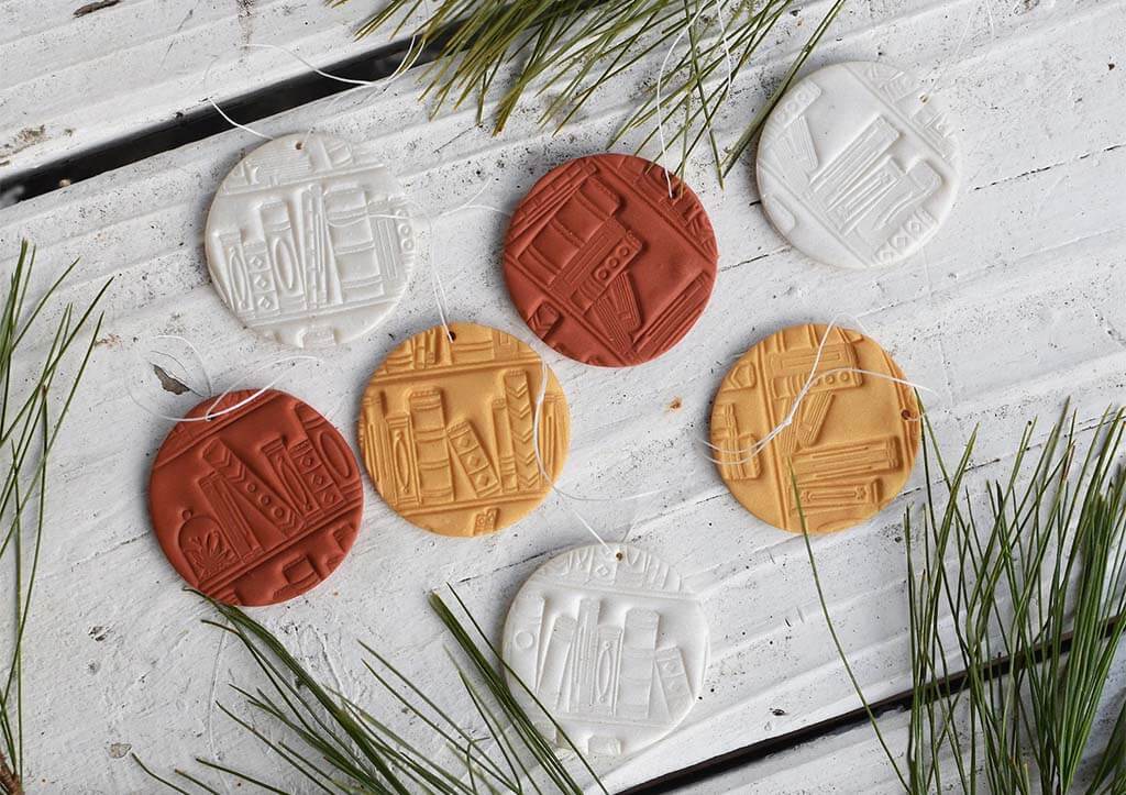 Round clay ornaments with a bookshelf imprint by LucyAndTheSheriff