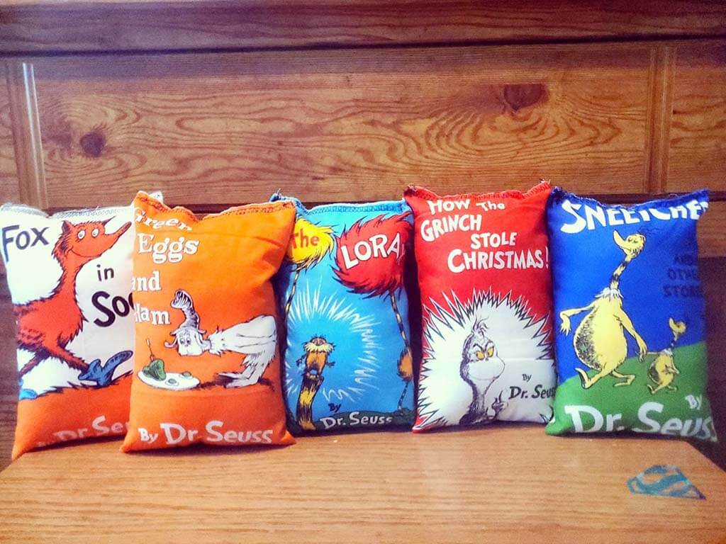 Pillows with fabric that looks like Dr. Seuss book covers by StitchingStarDesigns