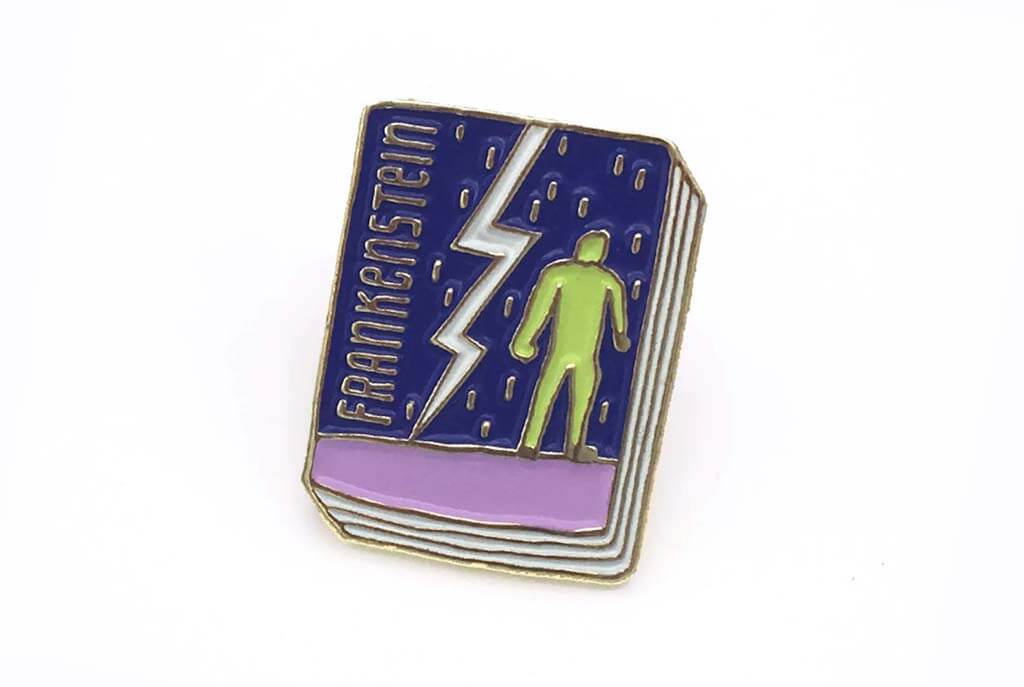 Book-shaped enamel pin with a lightning bolt and green man and the word "Frankenstein" by JaneMount