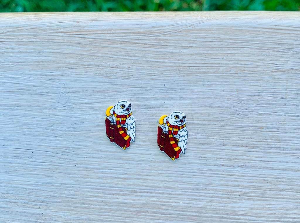 Earrings of a white owl with Gryffindor scarf and book by PineapplePixieDustCo