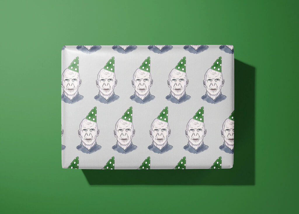 Wrapping paper with images of Voldemort wearing a green party hat by GlitteryBeard