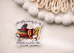Sticker with books, Hogwarts letter, and sorting hat plus the words "patiently waiting for my Hogwarts acceptance letter" by SavannahAndJamesCo