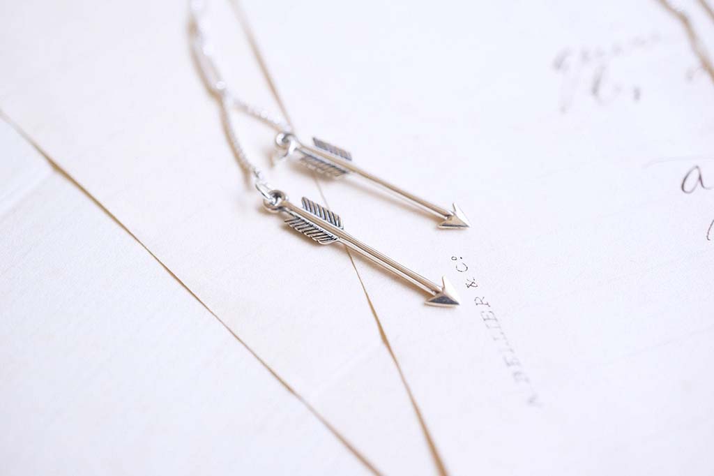 Silver earrings that look like arrows by StoryGirlCreations
