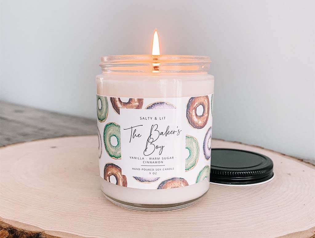 White candle with a label that reads "The Baker's Boy" by SaltyAndLit