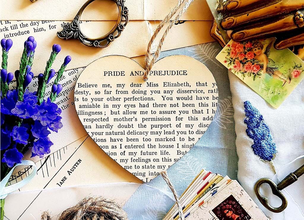 Heart-shaped ornament with an image of a page from Pride and Prejudice. By BeKindToYourshelf