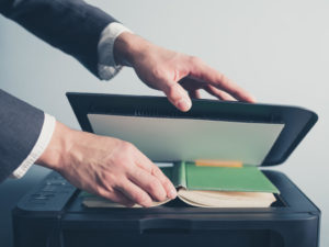 Man scanning a book in a copier