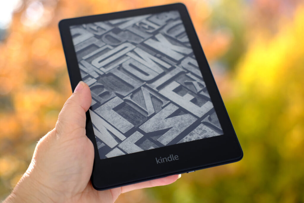 Picture of a hand holding a Kindle e-reader outside